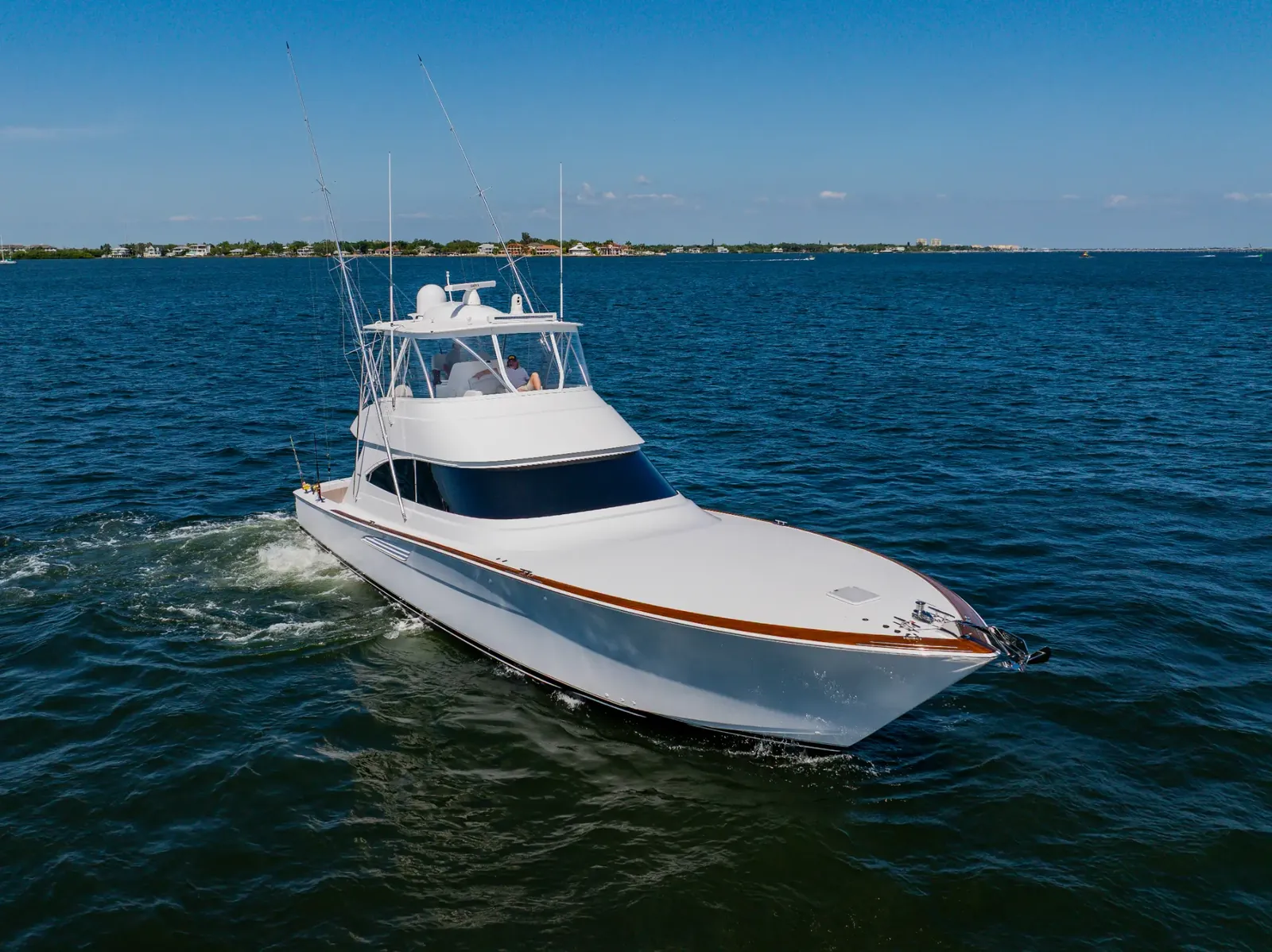 Mjolnir under way near the shoreline, her bow wake spreading